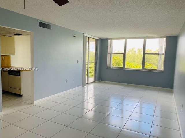 unfurnished room featuring a textured ceiling, baseboards, and light tile patterned floors