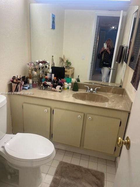 bathroom featuring toilet, tile patterned floors, and vanity