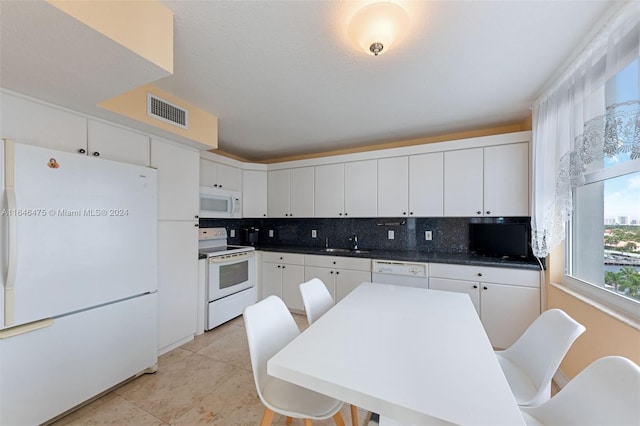 kitchen featuring white cabinetry, sink, backsplash, white appliances, and light tile patterned flooring