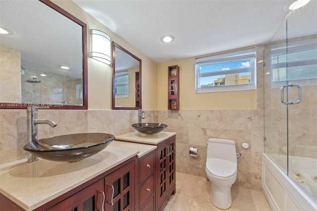 full bathroom featuring a textured ceiling, tile patterned flooring, tile walls, and toilet