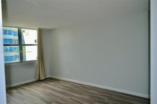 unfurnished room featuring a textured ceiling and hardwood / wood-style floors