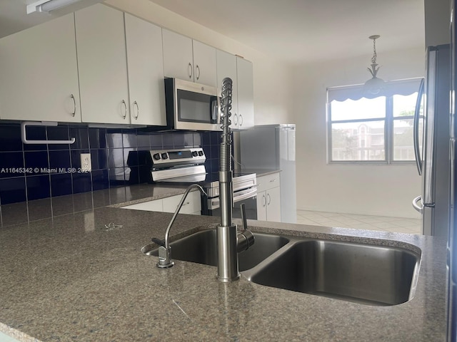 kitchen featuring appliances with stainless steel finishes, tasteful backsplash, decorative light fixtures, and white cabinets