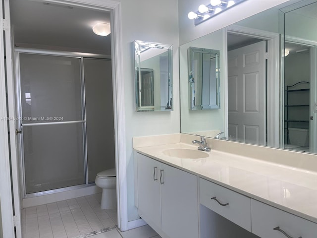 bathroom featuring tile patterned flooring, vanity, toilet, and an enclosed shower