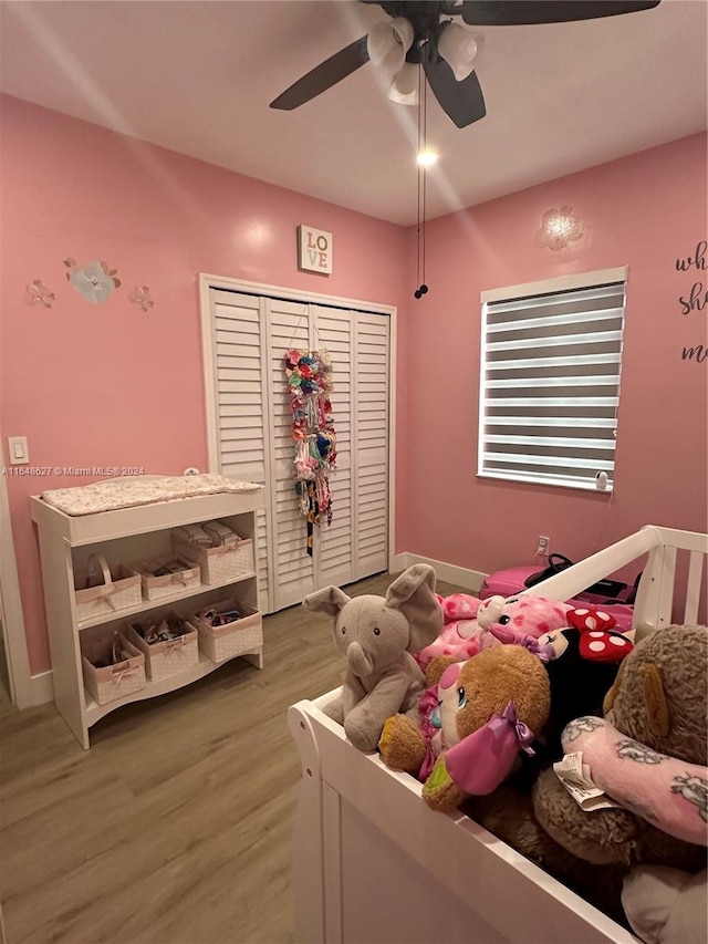 bedroom with hardwood / wood-style floors, ceiling fan, and a closet