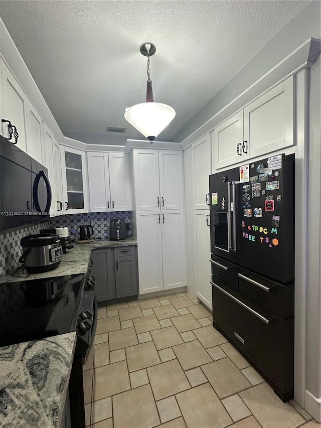 kitchen with white cabinets, backsplash, black appliances, pendant lighting, and a textured ceiling