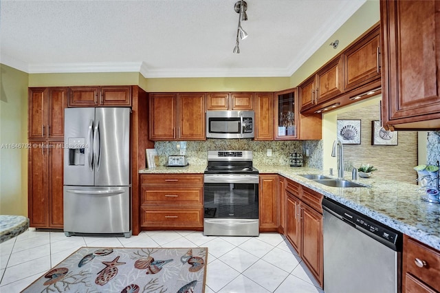 kitchen featuring appliances with stainless steel finishes, light stone countertops, ornamental molding, and sink