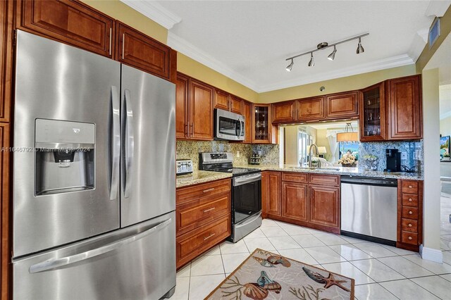 kitchen featuring ornamental molding, light tile patterned floors, stainless steel appliances, light stone counters, and sink