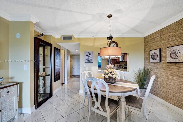 dining area featuring a textured ceiling, ornamental molding, and light tile patterned floors