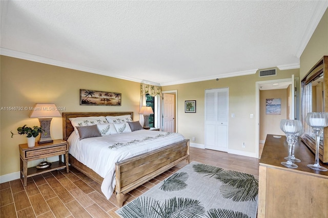 bedroom with crown molding, a textured ceiling, and wood-type flooring