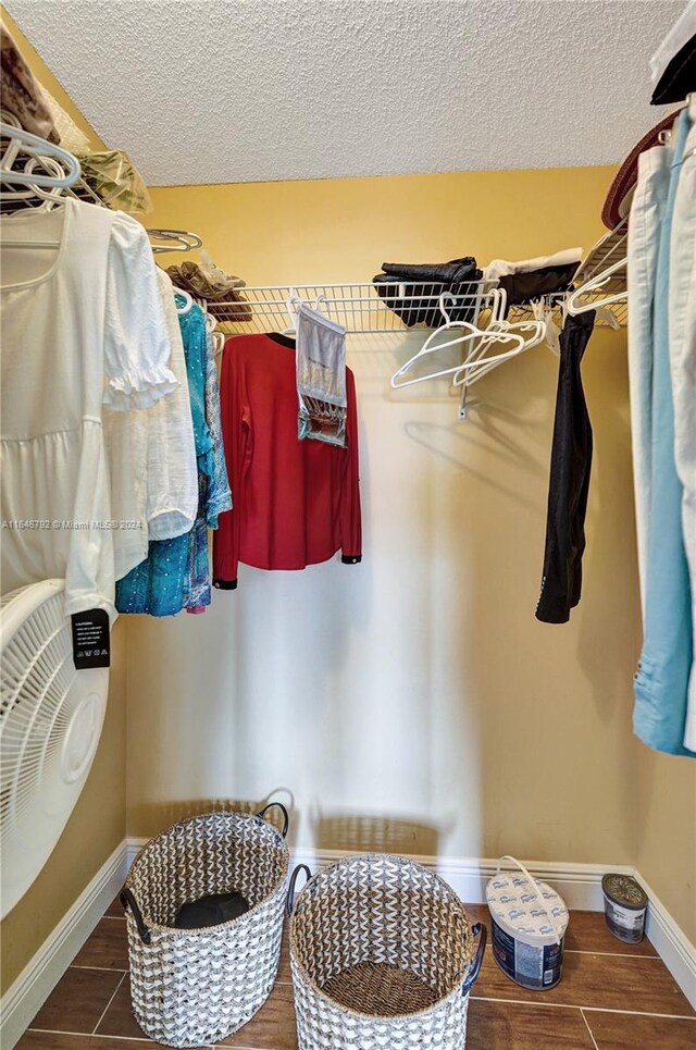 walk in closet with dark wood-type flooring