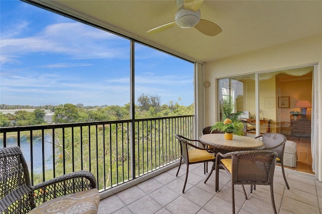 sunroom featuring a water view and ceiling fan