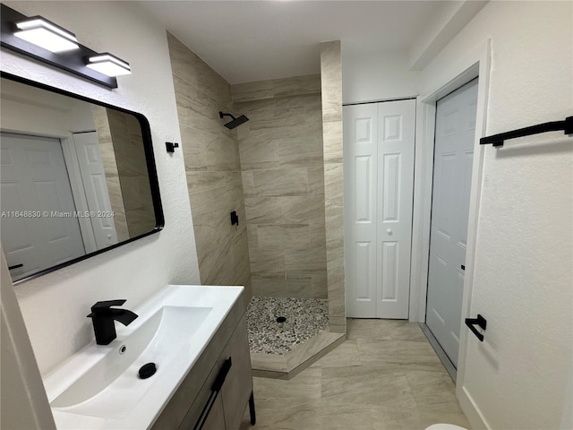 bathroom featuring tiled shower, vanity, and tile patterned floors