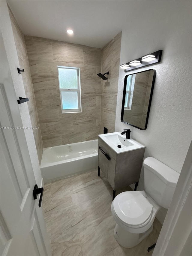 full bathroom with tiled shower / bath, toilet, tile patterned flooring, and vanity