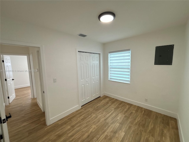 unfurnished bedroom with a closet, hardwood / wood-style floors, and electric panel