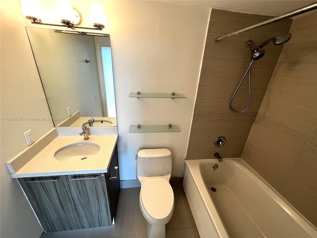 full bathroom with tiled shower / bath, toilet, tile patterned floors, and vanity