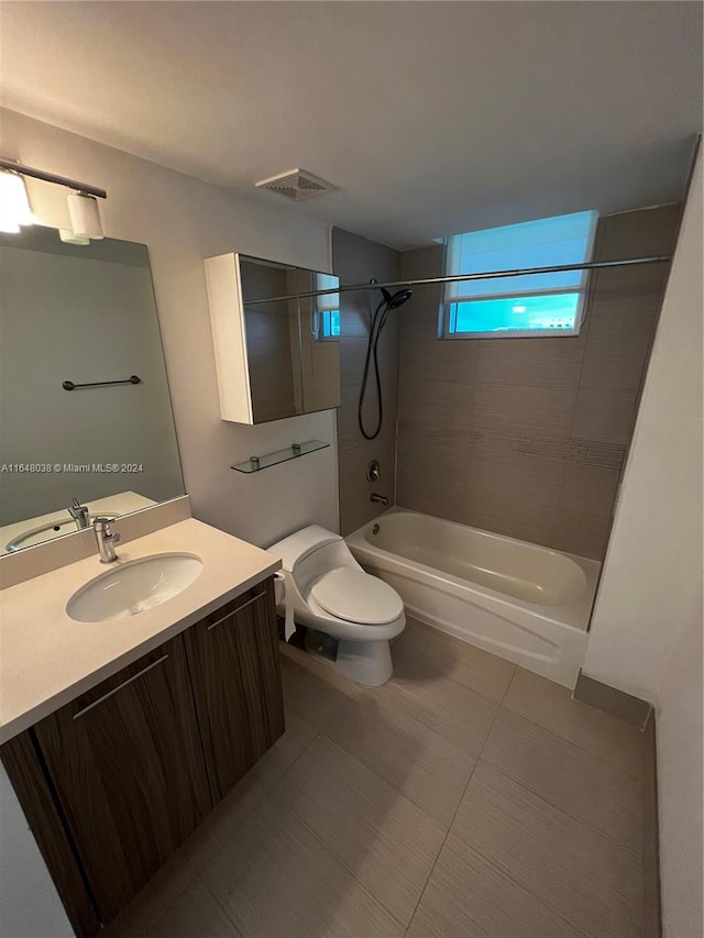 full bathroom featuring toilet, tiled shower / bath combo, vanity, and tile patterned floors