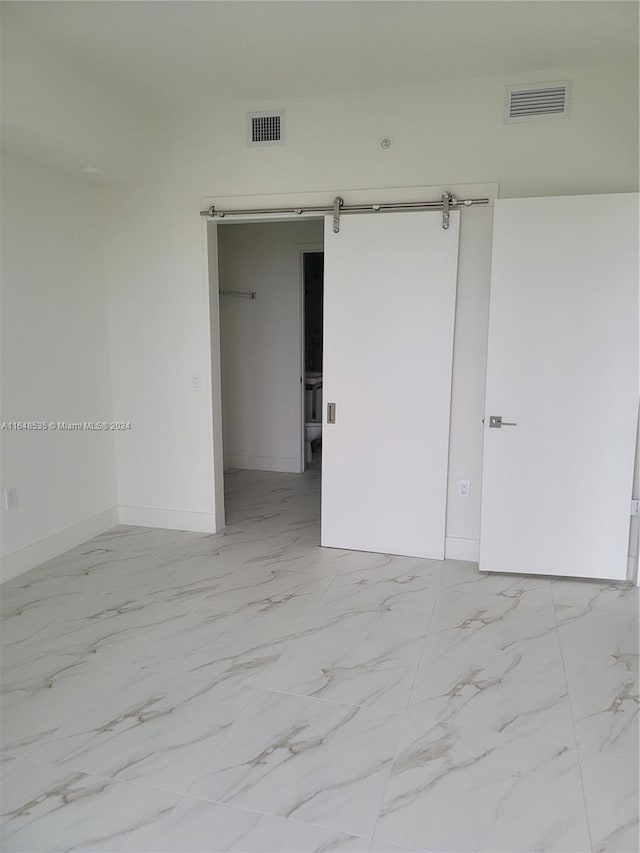 unfurnished room with a barn door