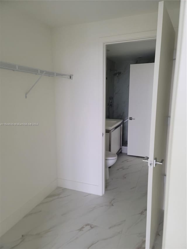 bathroom with vanity, toilet, and a tile shower