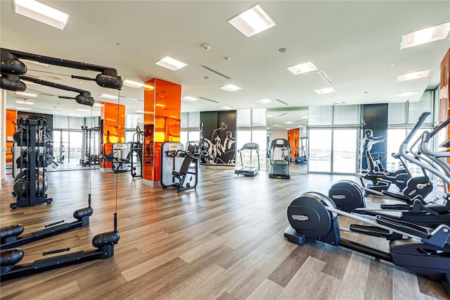 workout area with a wall of windows and hardwood / wood-style flooring