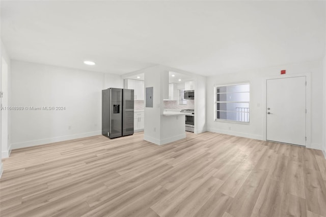 unfurnished living room with electric panel and light wood-type flooring