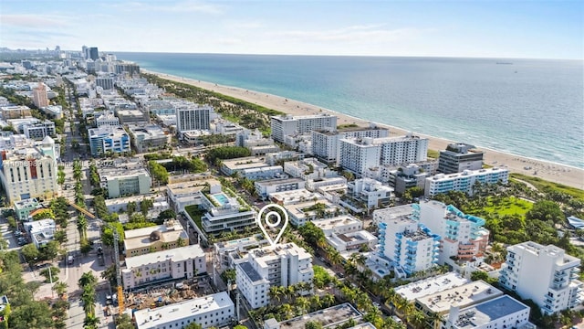 birds eye view of property featuring a beach view and a water view