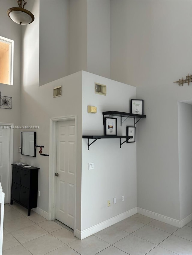 interior space with a high ceiling and light tile patterned floors