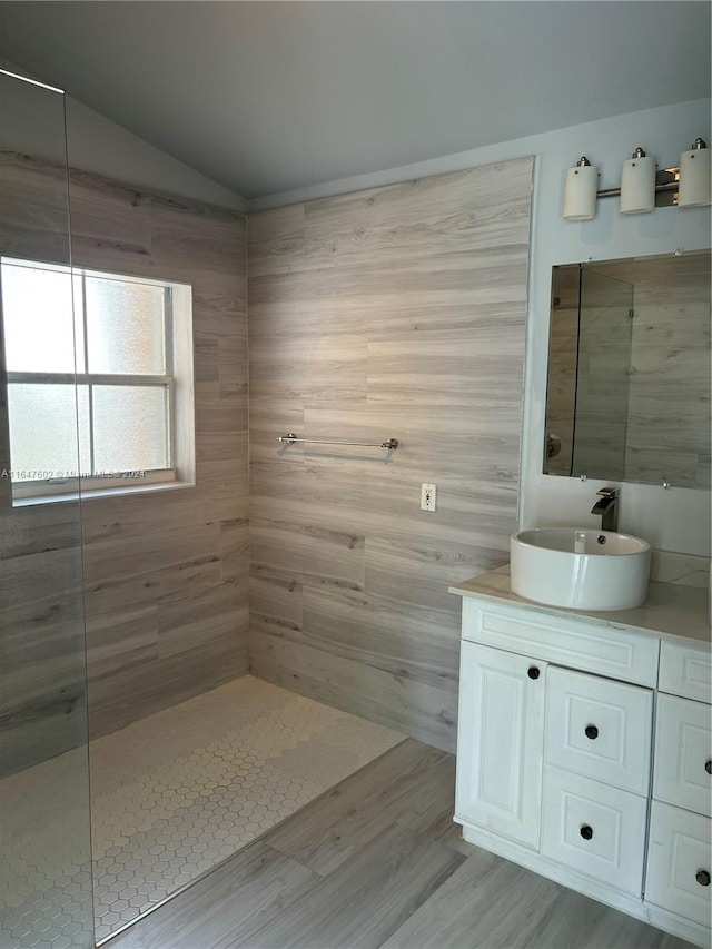 bathroom with tiled shower and vanity