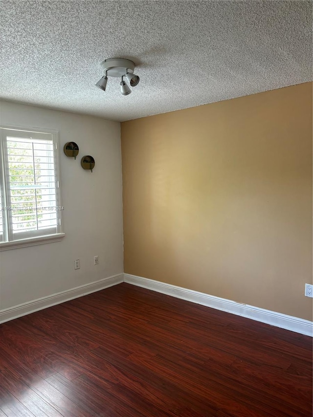 unfurnished room featuring a textured ceiling and hardwood / wood-style floors