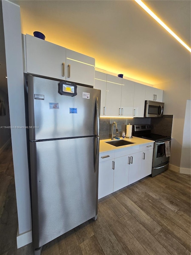 kitchen featuring a sink, white cabinetry, appliances with stainless steel finishes, tasteful backsplash, and dark wood finished floors