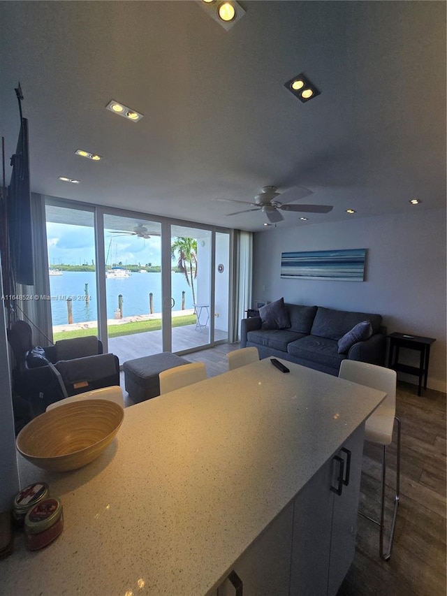 kitchen featuring a water view, open floor plan, dark wood finished floors, and recessed lighting