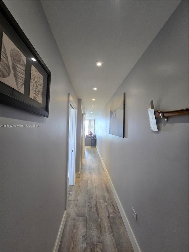 hallway featuring recessed lighting, wood finished floors, and baseboards