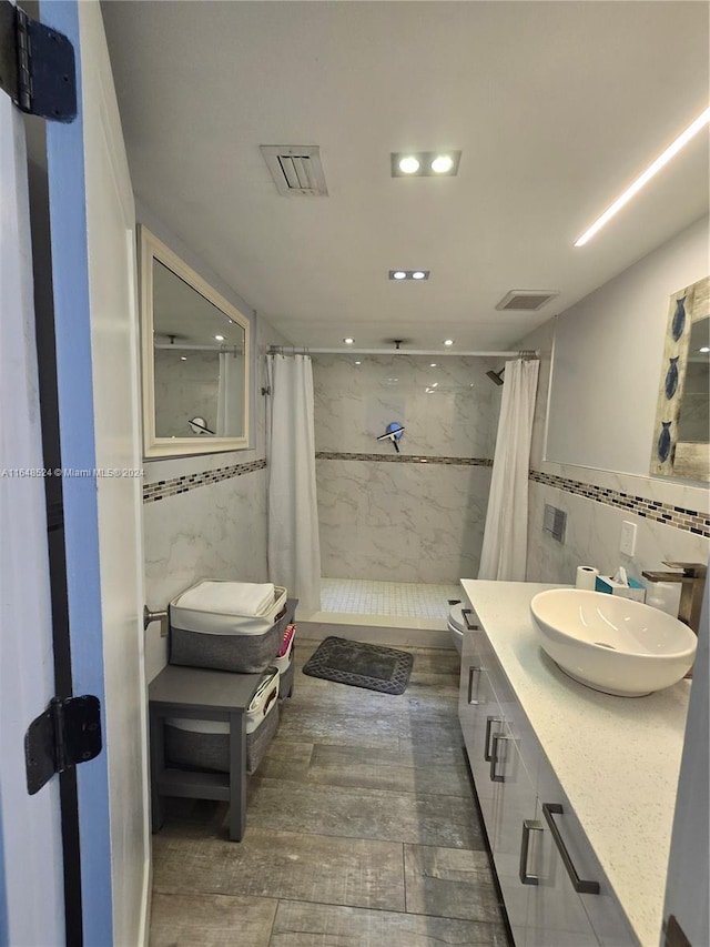 full bathroom featuring toilet, visible vents, vanity, tile walls, and a stall shower