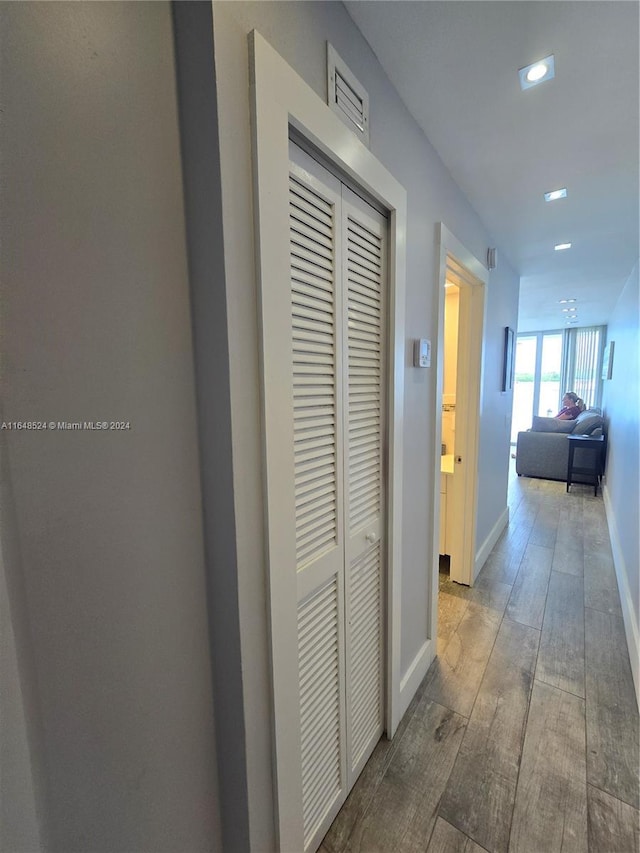 hallway featuring recessed lighting, baseboards, and wood finished floors