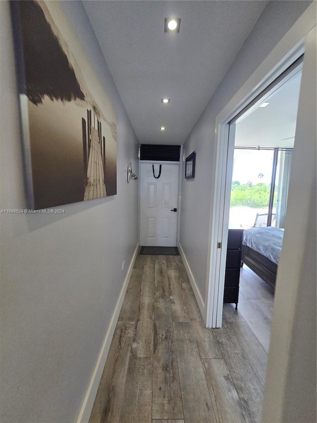 hallway with recessed lighting, baseboards, and wood finished floors