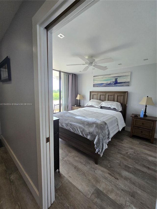 bedroom with dark wood finished floors, a ceiling fan, and baseboards