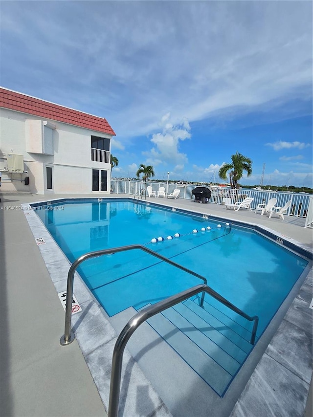 community pool featuring a patio area and fence