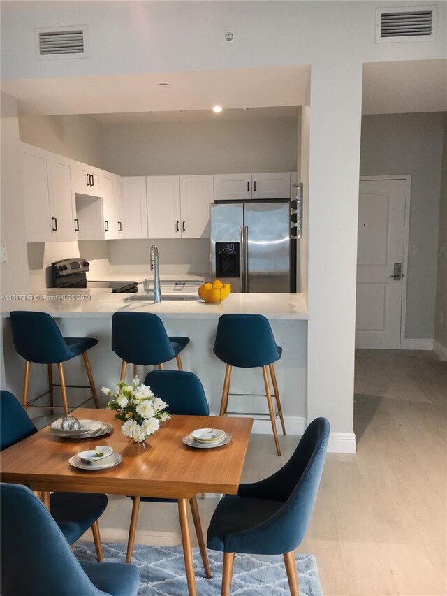 dining space with sink and light hardwood / wood-style flooring