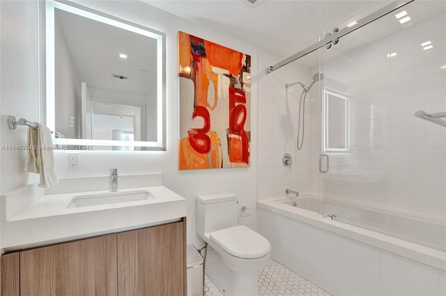 full bathroom with tile patterned flooring, vanity, toilet, and shower / bath combination with glass door