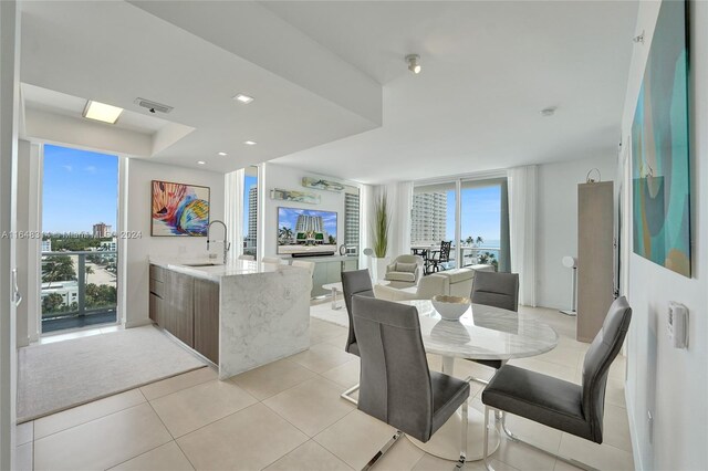 tiled dining area with plenty of natural light and sink