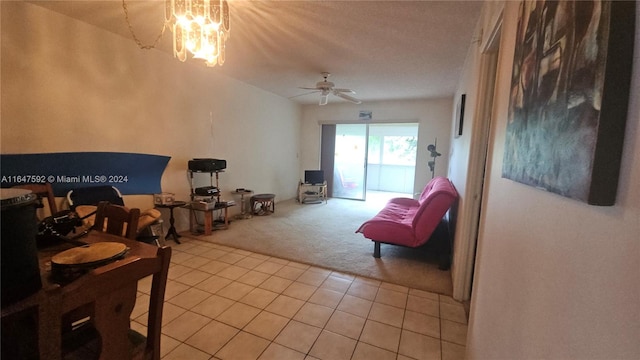 carpeted living room featuring ceiling fan with notable chandelier