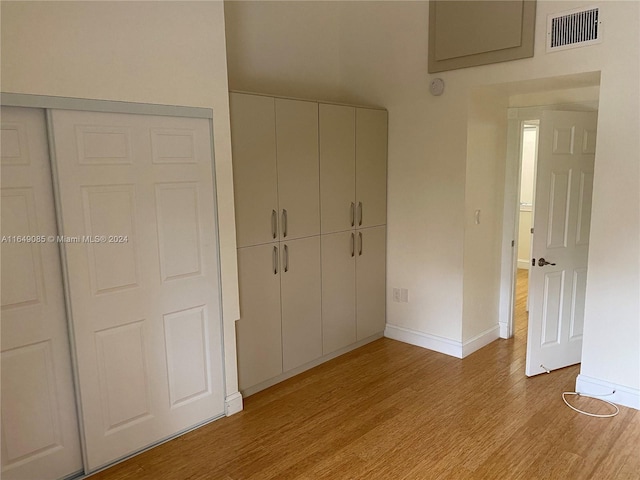 unfurnished bedroom with light wood-type flooring and a closet