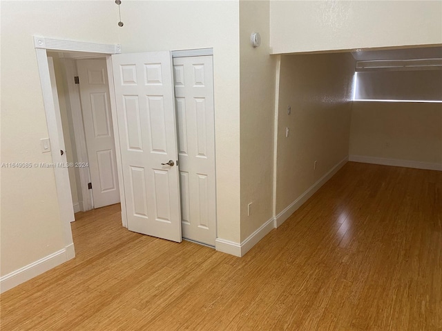 corridor with light hardwood / wood-style floors