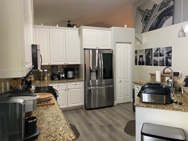 kitchen with light hardwood / wood-style flooring, backsplash, vaulted ceiling, stainless steel fridge with ice dispenser, and white cabinets