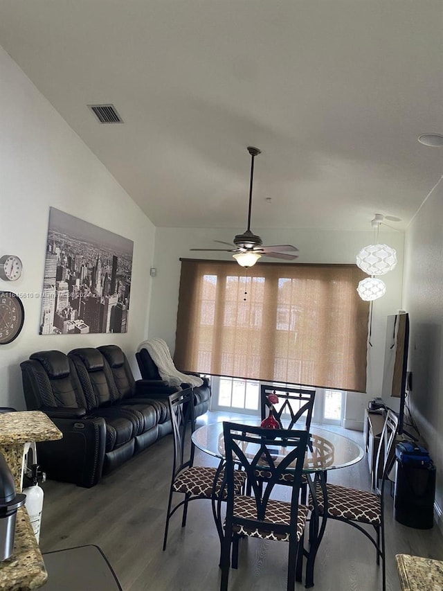 dining room featuring lofted ceiling, hardwood / wood-style flooring, and ceiling fan