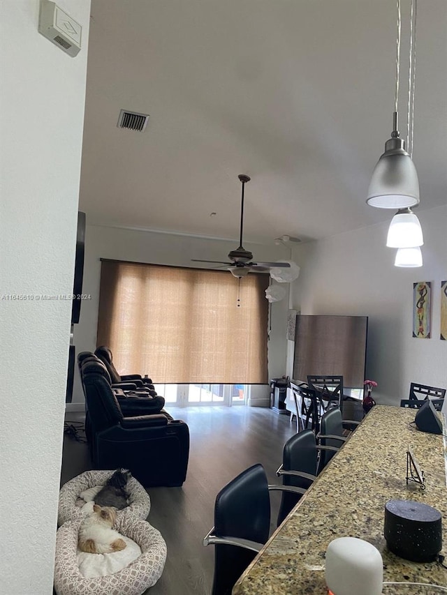 kitchen with pendant lighting, light stone countertops, hardwood / wood-style flooring, and ceiling fan