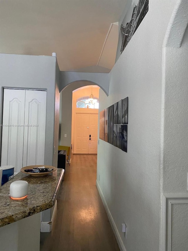 hallway featuring vaulted ceiling and dark hardwood / wood-style floors