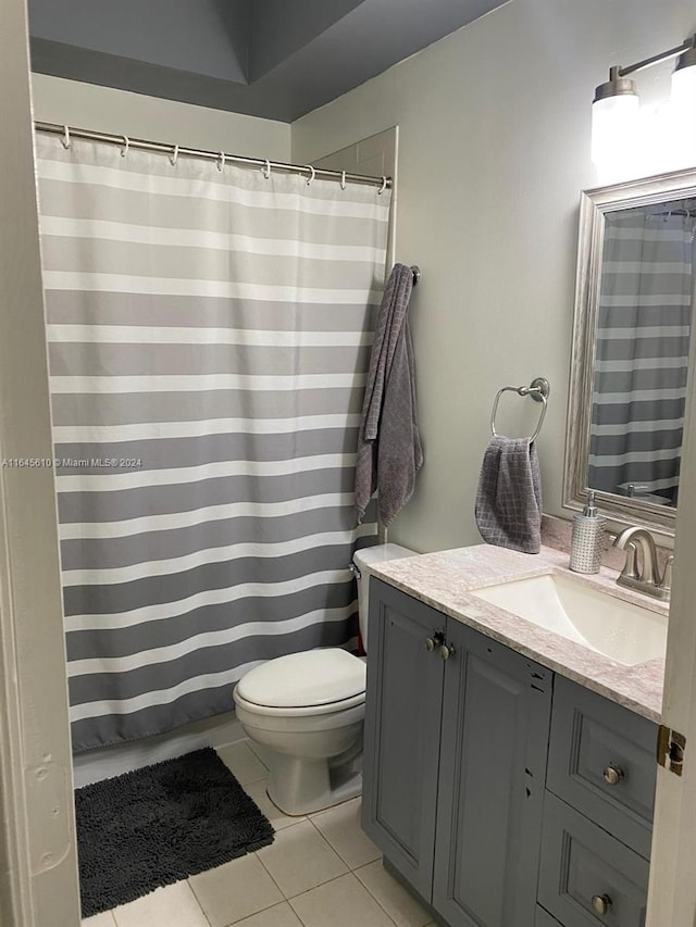 bathroom featuring vanity, toilet, and tile patterned flooring