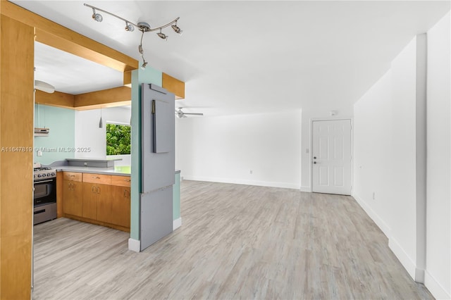 kitchen with stainless steel gas range oven, ceiling fan, and light hardwood / wood-style flooring