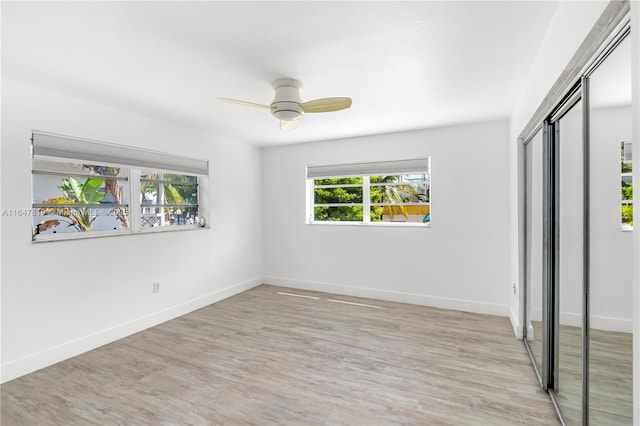 unfurnished bedroom with ceiling fan, a closet, and light wood-type flooring