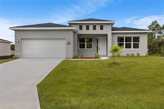 prairie-style house with a garage and a front lawn